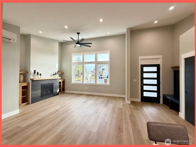 109 Sunrise Ave SE, Ocean Shores, WA 98569 - unfurnished living room with a fireplace, a ceiling fan, recessed lighting, light wood-type flooring, and an AC wall unit