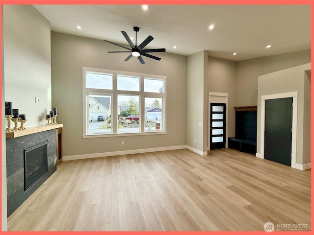 109 Sunrise Ave SE, Ocean Shores, WA 98569 - unfurnished living room with a fireplace, light wood-style flooring, a ceiling fan, recessed lighting, and baseboards