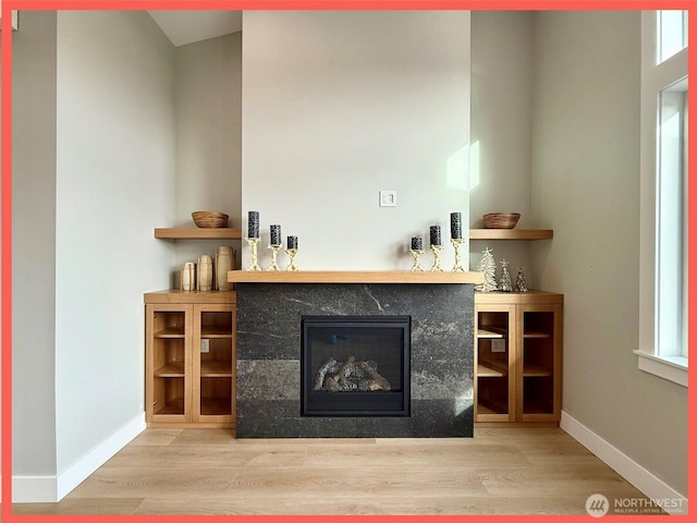 109 Sunrise Ave SE, Ocean Shores, WA 98569 - living area with wood finished floors, baseboards, and a glass covered fireplace