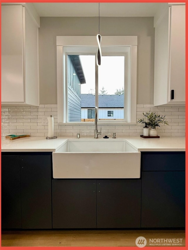 109 Sunrise Ave SE, Ocean Shores, WA 98569 - kitchen with a sink, light countertops, backsplash, and white cabinetry