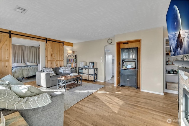 living room featuring hardwood / wood-style floors, a barn door, and a textured ceiling