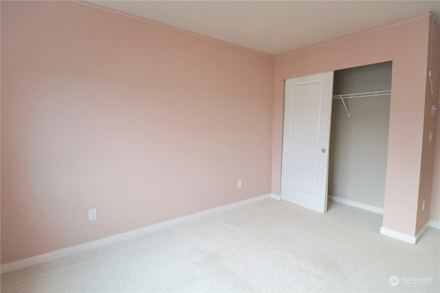 unfurnished bedroom with a closet and light carpet