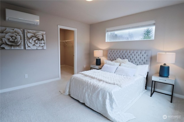 bedroom featuring a spacious closet, a closet, light carpet, and an AC wall unit