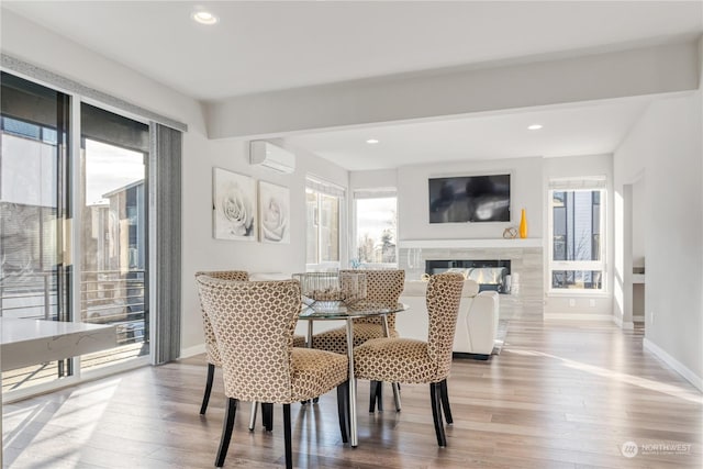 dining room with wood-type flooring and a wall unit AC