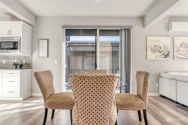 dining area with an AC wall unit, plenty of natural light, and light wood-type flooring