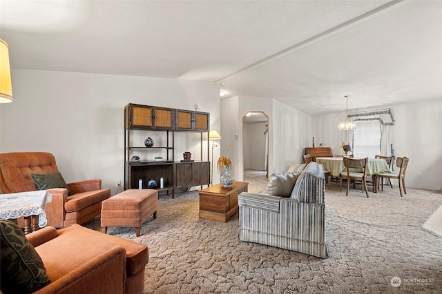 carpeted living room featuring a chandelier and lofted ceiling