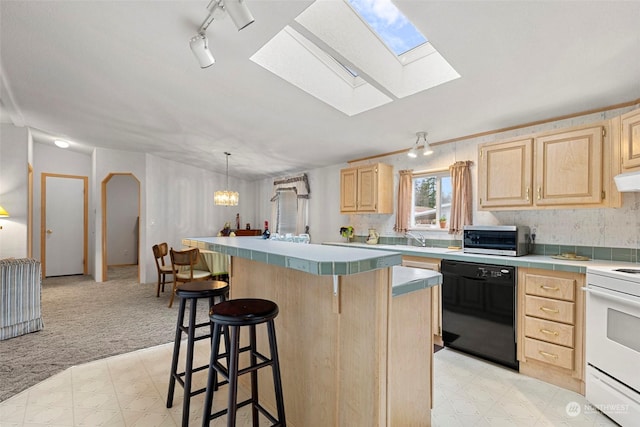 kitchen featuring a skylight, dishwasher, a center island, and light brown cabinets