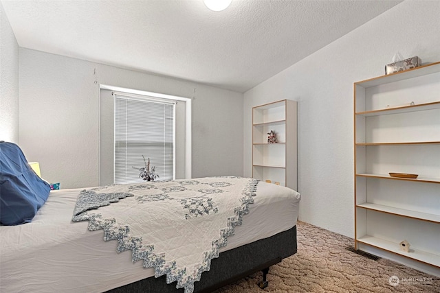 bedroom with a textured ceiling and carpet floors