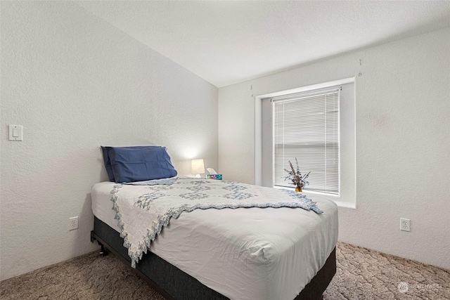 bedroom with carpet flooring and lofted ceiling