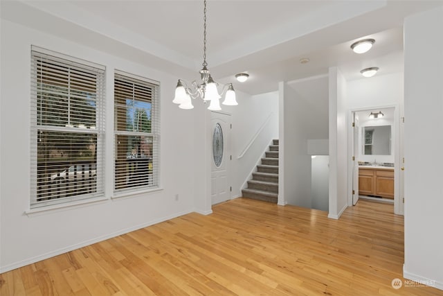 interior space with a chandelier, light wood-type flooring, and sink