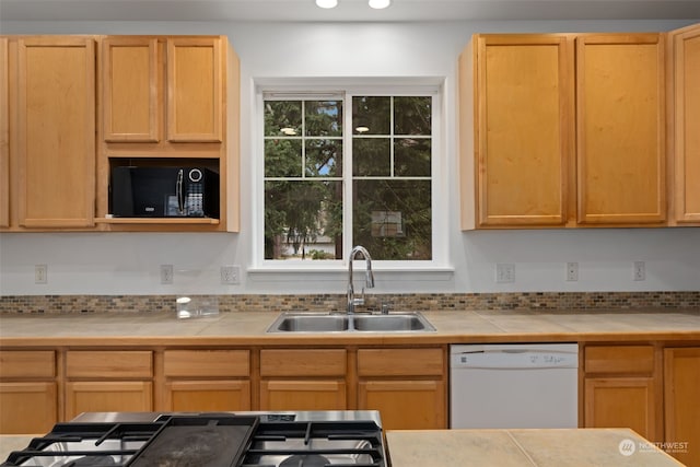 kitchen with tile countertops, sink, white dishwasher, and light brown cabinetry