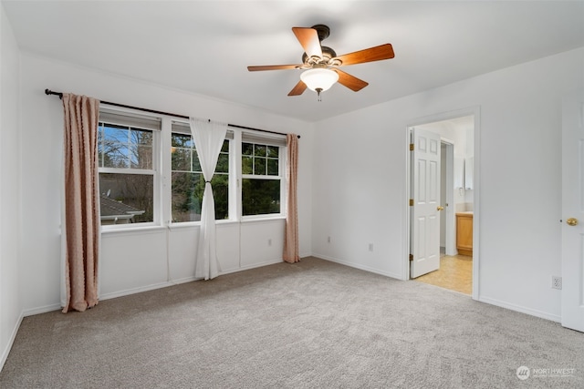 unfurnished bedroom featuring ensuite bathroom, ceiling fan, and light colored carpet