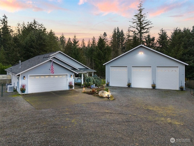 ranch-style home with an outbuilding, a garage, and central air condition unit