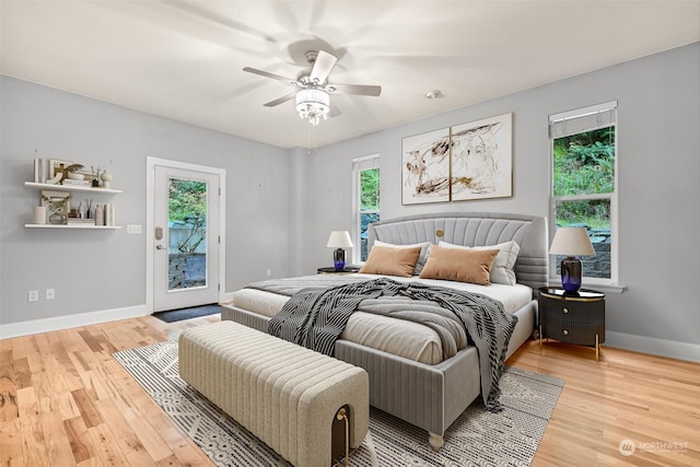 bedroom featuring multiple windows, access to outside, ceiling fan, and light hardwood / wood-style floors