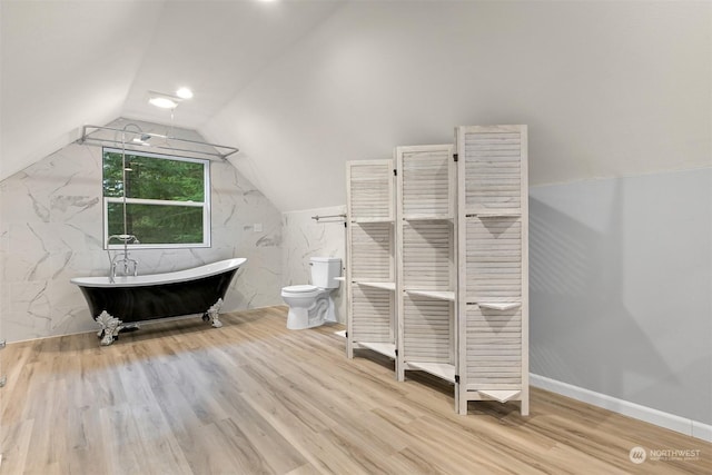 bathroom with a bath, vaulted ceiling, toilet, and wood-type flooring