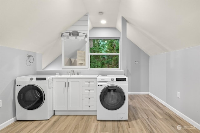 laundry area with cabinets, washer / dryer, light wood-type flooring, and sink