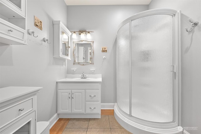 bathroom featuring tile patterned flooring, vanity, and a shower with shower door