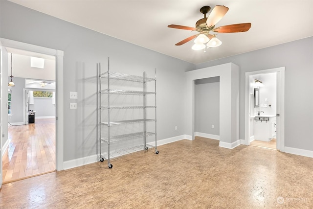 unfurnished bedroom featuring ensuite bath, ceiling fan, and sink