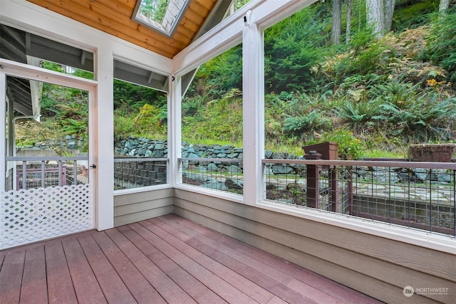 unfurnished sunroom featuring lofted ceiling with skylight and wooden ceiling