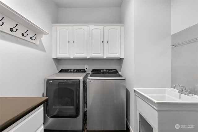 clothes washing area with cabinets, washer and clothes dryer, and sink