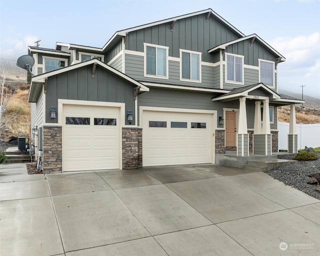 craftsman house with central AC unit and a garage