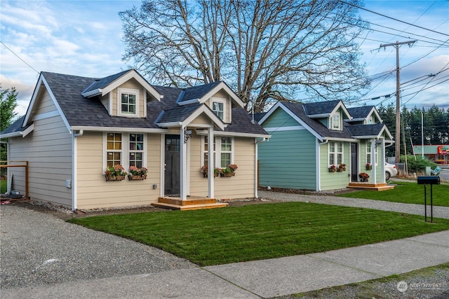 cape cod house featuring a front yard