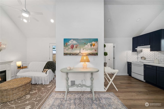 interior space featuring ceiling fan, tasteful backsplash, high vaulted ceiling, dark hardwood / wood-style floors, and range with electric stovetop