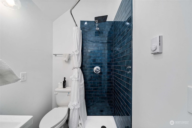 bathroom featuring a shower with curtain and toilet