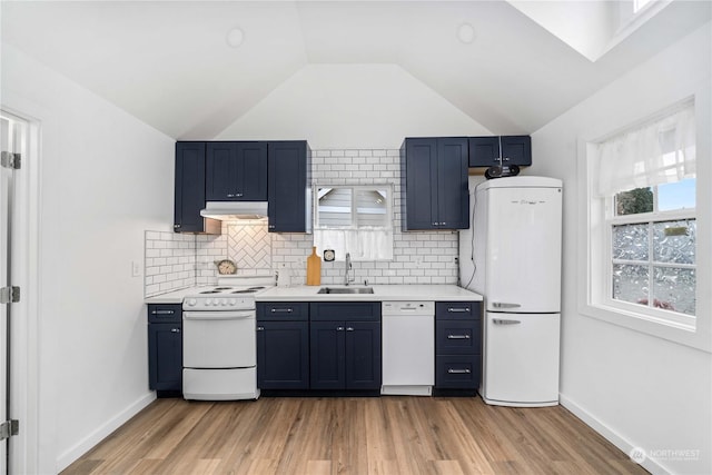 kitchen with light hardwood / wood-style floors, white appliances, lofted ceiling, and sink