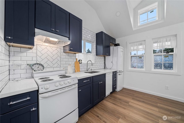 kitchen featuring decorative backsplash, vaulted ceiling, sink, dishwasher, and range