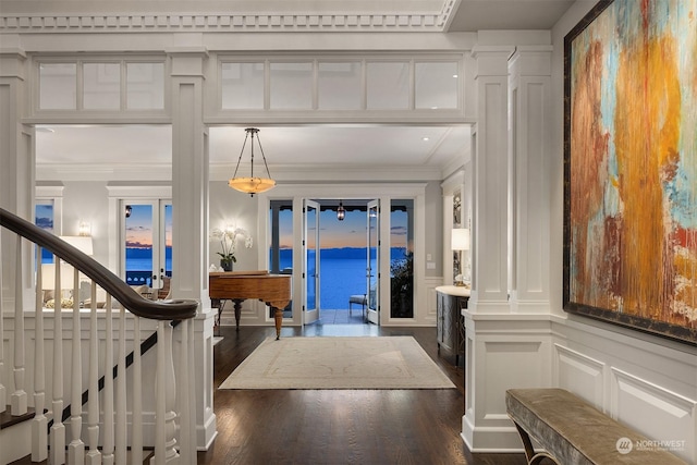 entrance foyer featuring ornamental molding, dark hardwood / wood-style flooring, and a water view