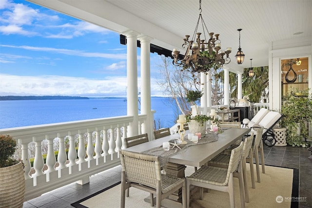 sunroom / solarium with a notable chandelier and a water view