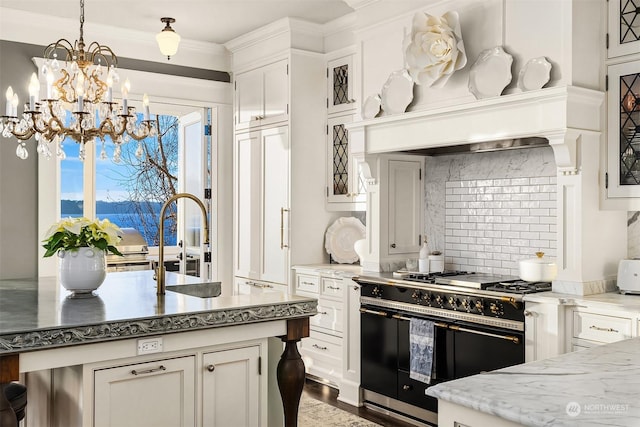 kitchen featuring white cabinets, pendant lighting, double oven range, and tasteful backsplash