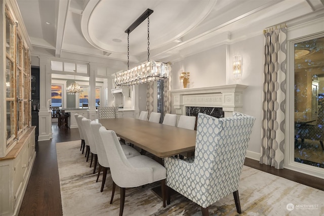 dining space featuring coffered ceiling, dark hardwood / wood-style floors, a high end fireplace, ornamental molding, and beamed ceiling