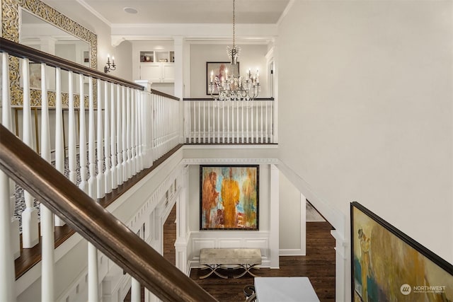 stairway featuring a notable chandelier, hardwood / wood-style floors, and crown molding