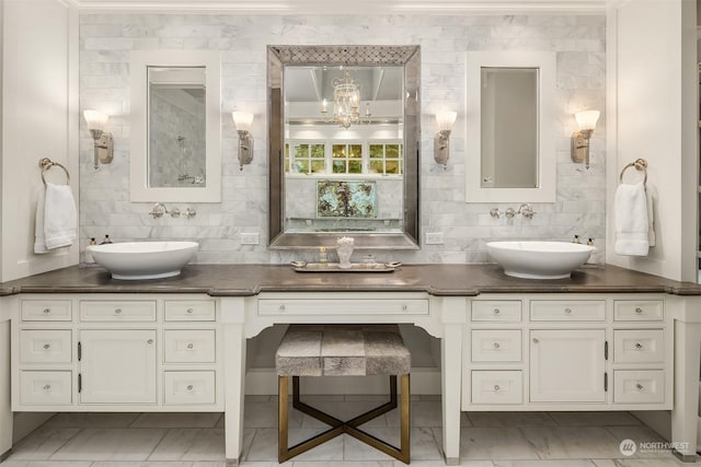 bathroom with tasteful backsplash, an inviting chandelier, and vanity