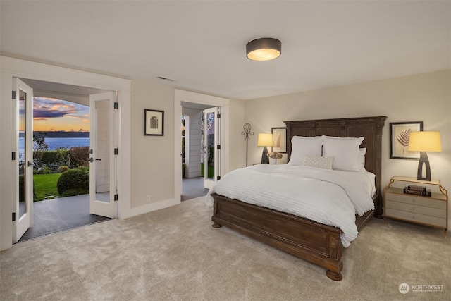 bedroom with french doors, access to exterior, and light colored carpet