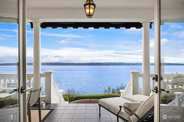 exterior space with french doors and a water view