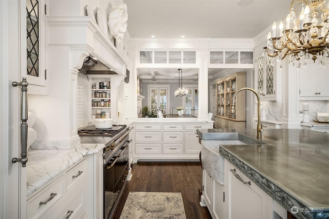 kitchen featuring decorative light fixtures, white cabinets, range with two ovens, and dark hardwood / wood-style floors