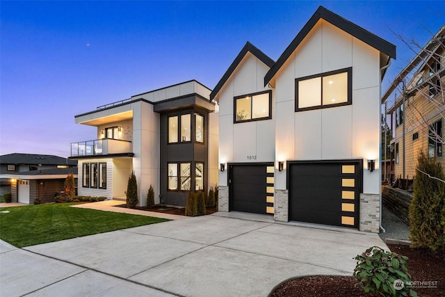 contemporary home featuring a yard, a balcony, and a garage