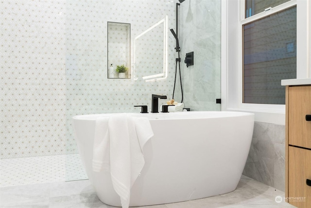 bathroom featuring separate shower and tub and tile walls