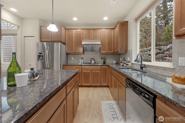 kitchen featuring stainless steel appliances, a healthy amount of sunlight, a sink, and tasteful backsplash