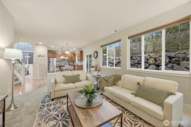 living area featuring recessed lighting, visible vents, and stairway