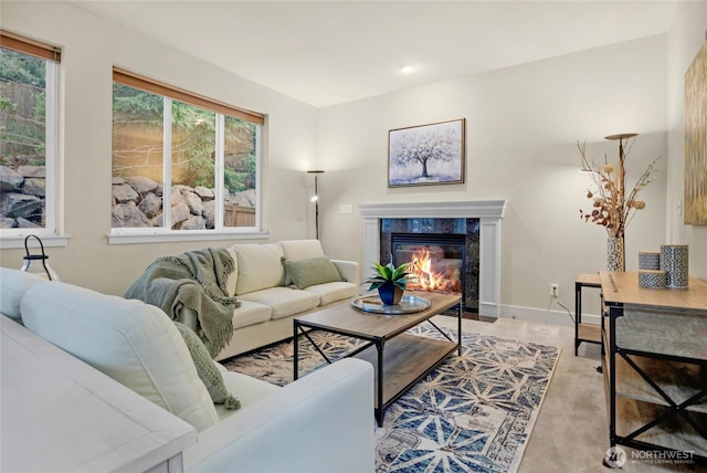 living room with a high end fireplace and baseboards