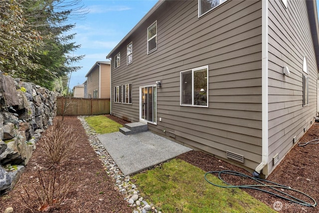 rear view of house featuring entry steps, crawl space, a patio area, and fence