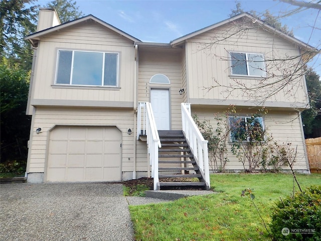 split foyer home with a garage and a front lawn