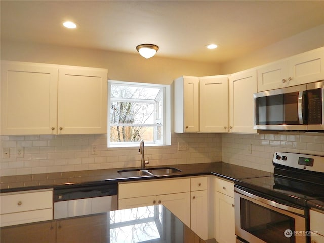 kitchen with white cabinets, appliances with stainless steel finishes, decorative backsplash, and sink