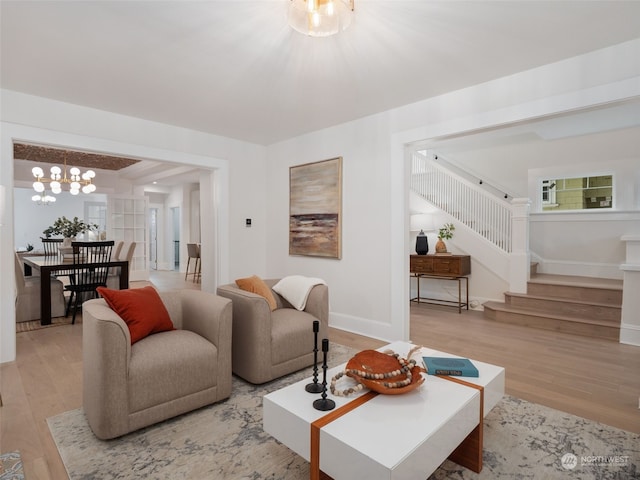 living room with an inviting chandelier and light hardwood / wood-style flooring