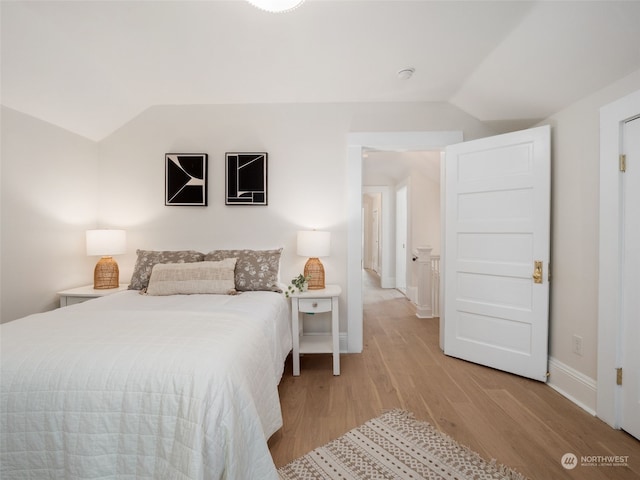 bedroom with lofted ceiling and light hardwood / wood-style floors