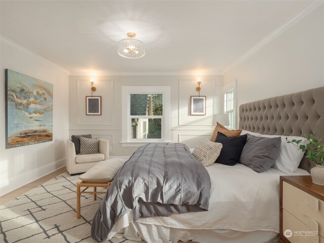 bedroom featuring ornamental molding, light hardwood / wood-style flooring, and an inviting chandelier